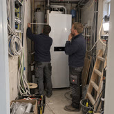 Zwei Installateure vor einem Warmwasserspeicher